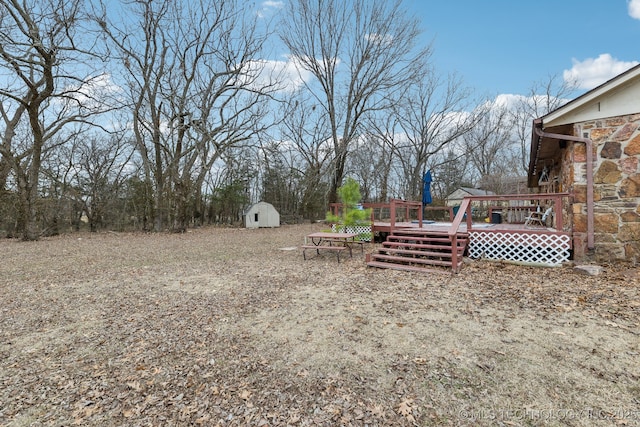 view of yard with a wooden deck and a shed