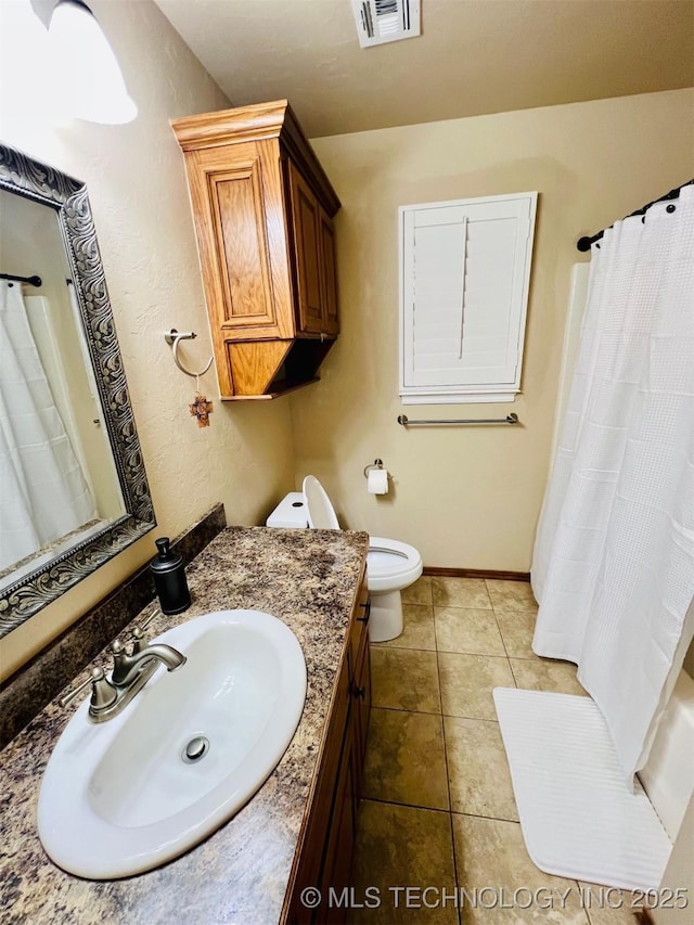 bathroom with vanity, tile patterned floors, toilet, and walk in shower