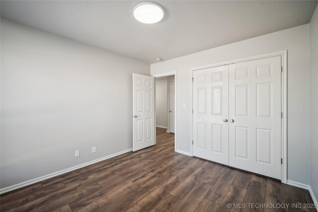 unfurnished bedroom featuring dark hardwood / wood-style floors and a closet