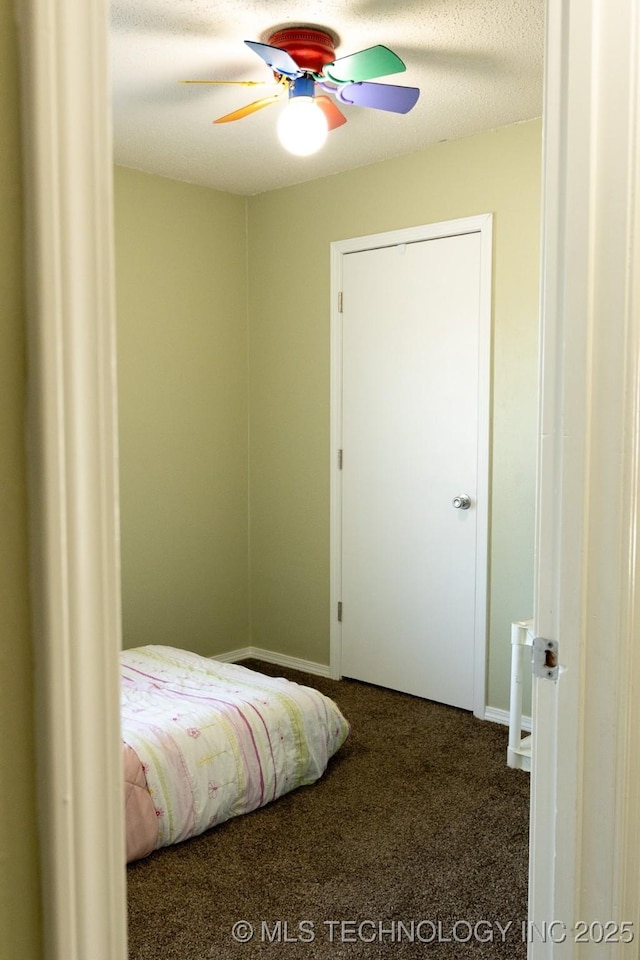 carpeted bedroom featuring ceiling fan and a textured ceiling