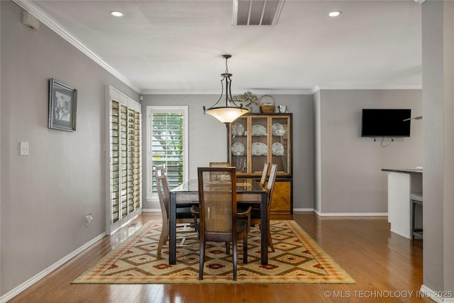 dining space with crown molding and dark hardwood / wood-style floors