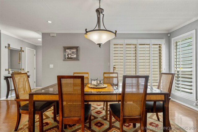 dining area featuring crown molding and wood-type flooring