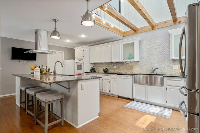 kitchen featuring pendant lighting, sink, dark stone countertops, white cabinets, and white appliances