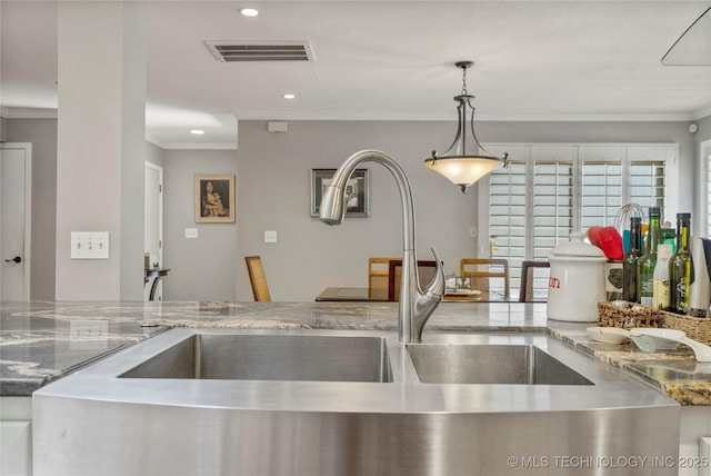 kitchen with hanging light fixtures, crown molding, and sink