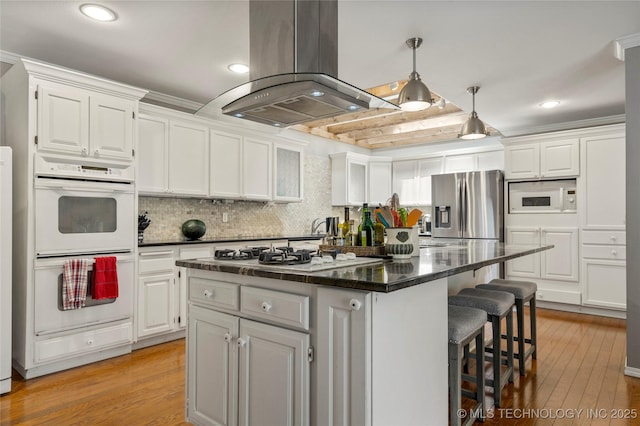 kitchen with a center island, island range hood, white cabinets, and white appliances