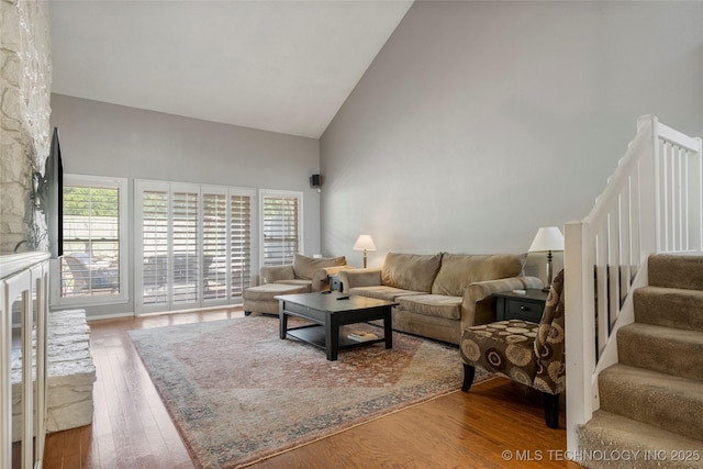 living room featuring hardwood / wood-style flooring, high vaulted ceiling, and a healthy amount of sunlight