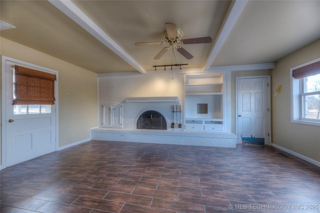 unfurnished living room featuring beam ceiling, a fireplace, and ceiling fan