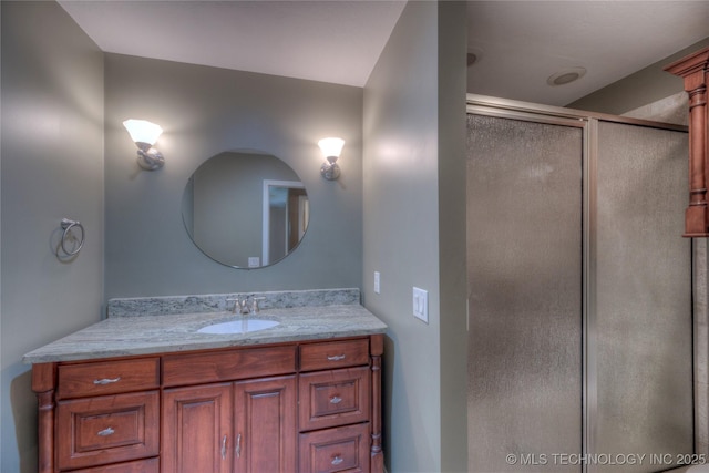 bathroom featuring vanity and a shower with shower door