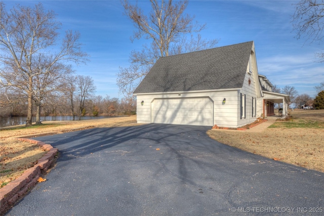 view of home's exterior featuring a garage, a water view, and a porch