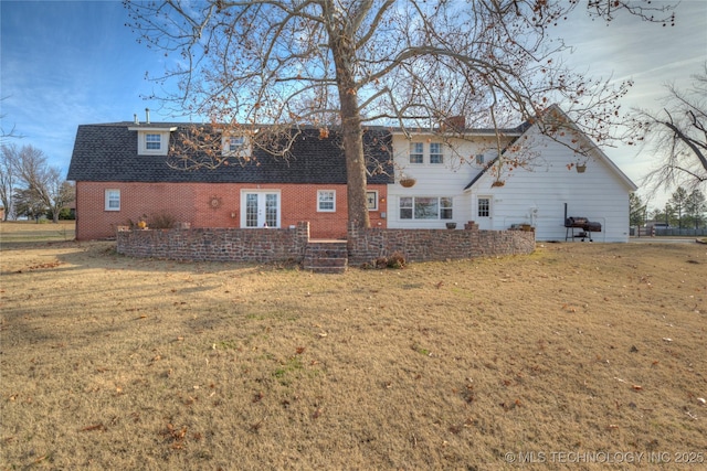 back of property featuring a lawn