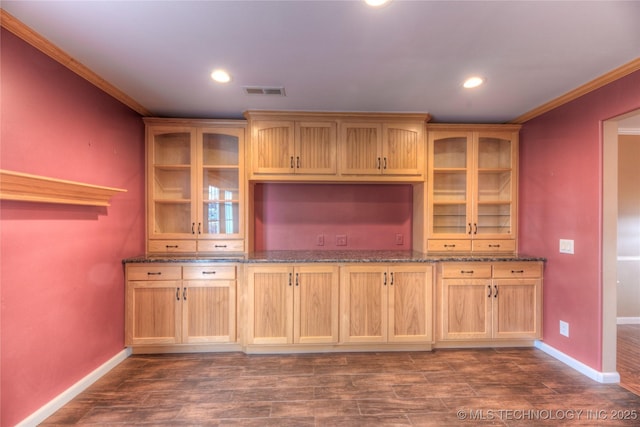 kitchen featuring ornamental molding, dark hardwood / wood-style floors, and dark stone countertops