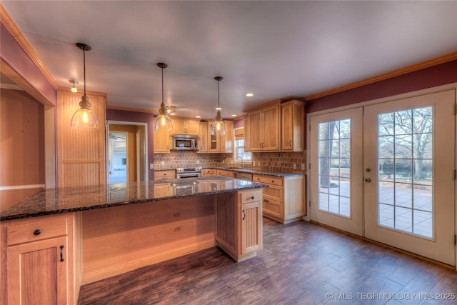 kitchen featuring appliances with stainless steel finishes, decorative light fixtures, and a kitchen island