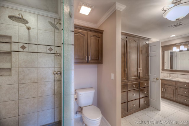 bathroom featuring a tile shower, vanity, toilet, crown molding, and tile patterned floors