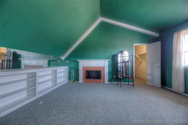 unfurnished living room with lofted ceiling, carpet flooring, and a fireplace