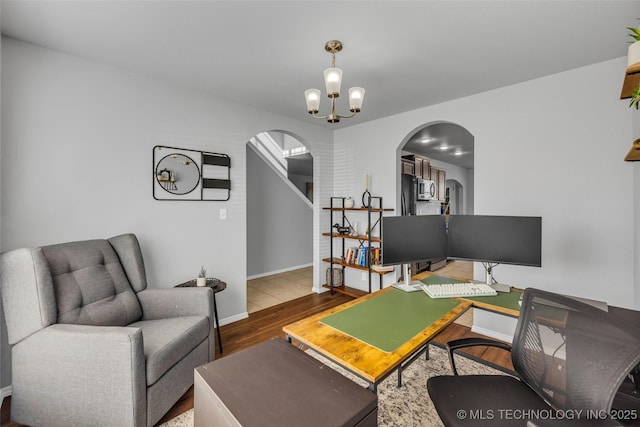 office space featuring an inviting chandelier and hardwood / wood-style floors