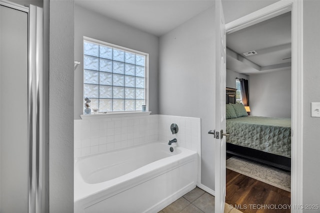 bathroom with hardwood / wood-style flooring and a tub