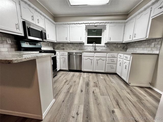 kitchen featuring white cabinetry, appliances with stainless steel finishes, sink, and decorative backsplash