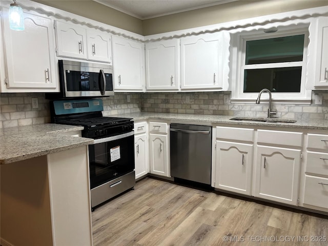 kitchen featuring stainless steel appliances, light hardwood / wood-style floors, sink, and white cabinets