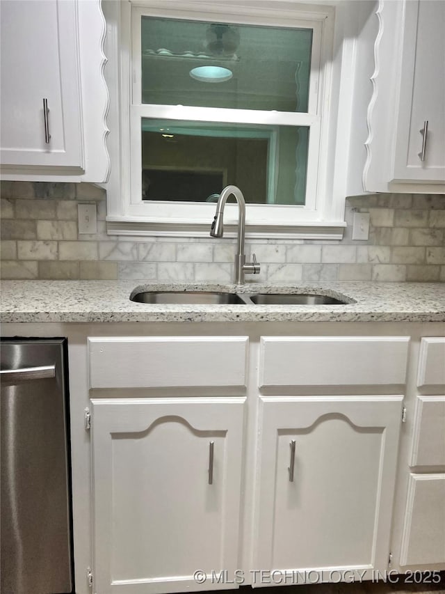 kitchen featuring white cabinetry, sink, and decorative backsplash