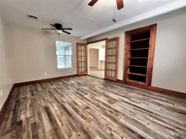 unfurnished living room featuring hardwood / wood-style floors, ceiling fan, and built in shelves