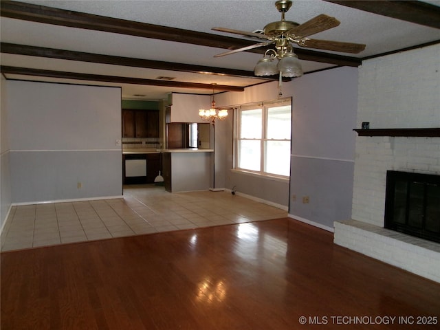 unfurnished living room featuring light wood finished floors, baseboards, a ceiling fan, beamed ceiling, and a fireplace