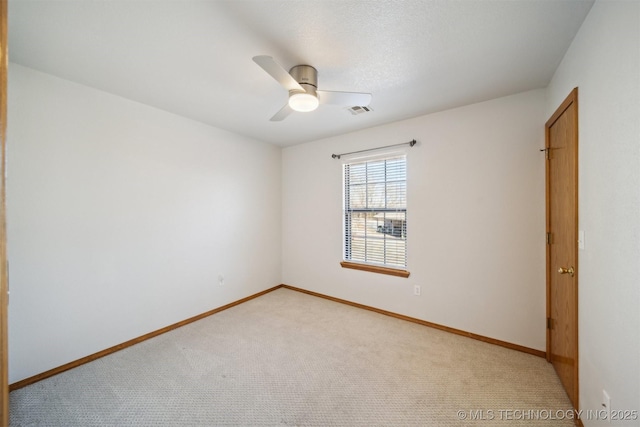 spare room with light colored carpet and ceiling fan