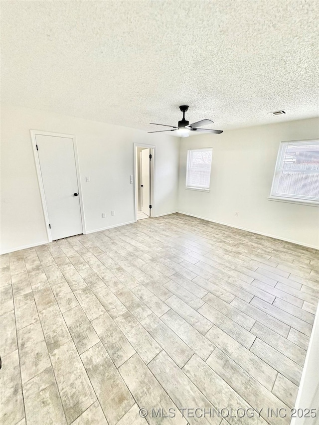 unfurnished room featuring a textured ceiling, ceiling fan, and light hardwood / wood-style floors