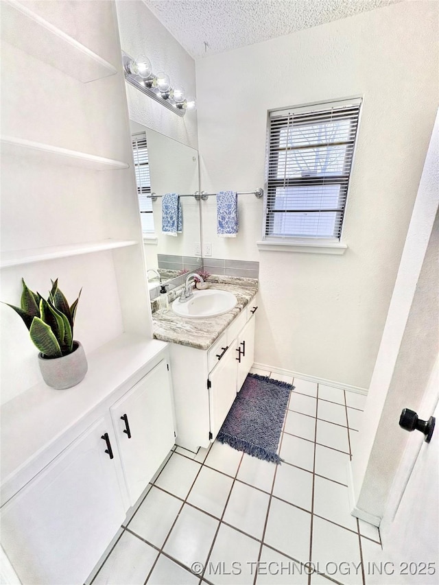 bathroom featuring vanity, tile patterned floors, and a textured ceiling