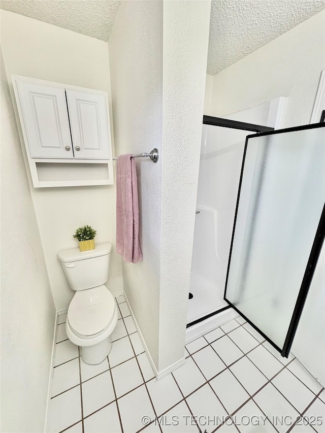 bathroom with tile patterned flooring, an enclosed shower, a textured ceiling, and toilet