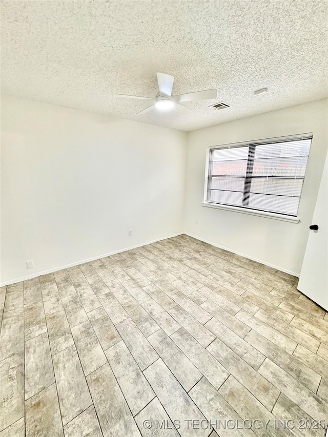 spare room featuring ceiling fan, a textured ceiling, and light wood-type flooring