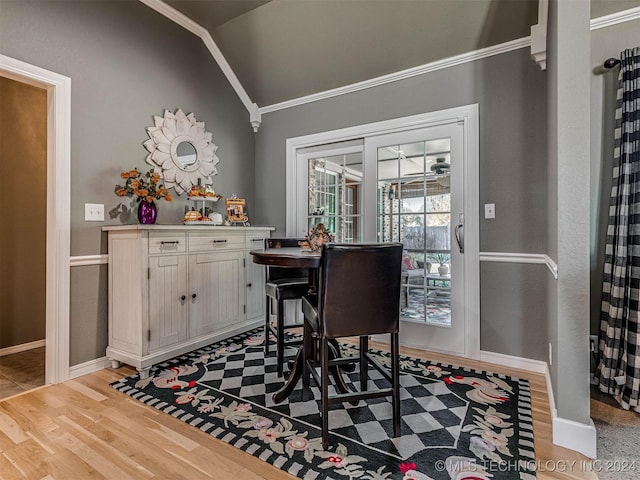 bar featuring crown molding, vaulted ceiling, and light wood-type flooring