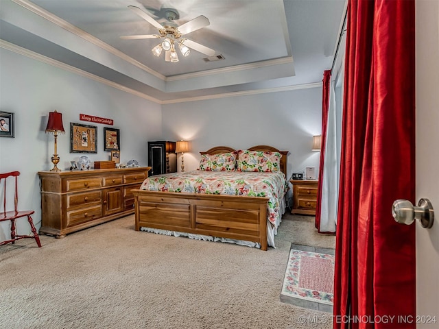 carpeted bedroom with ornamental molding, a raised ceiling, and ceiling fan