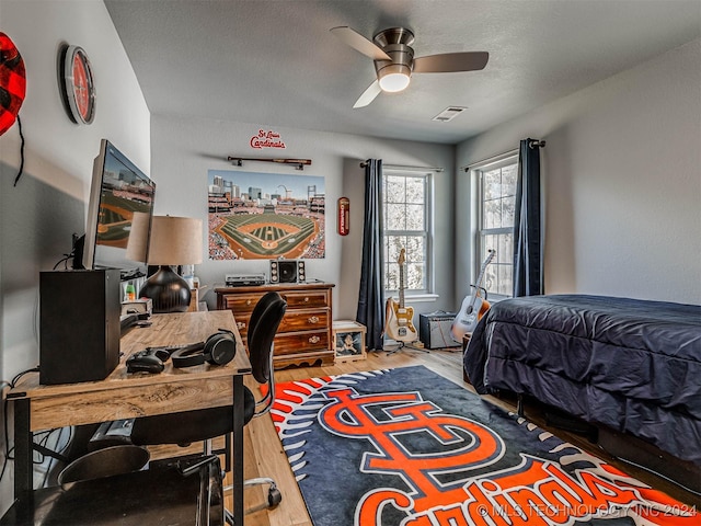 bedroom with hardwood / wood-style flooring, a textured ceiling, and ceiling fan