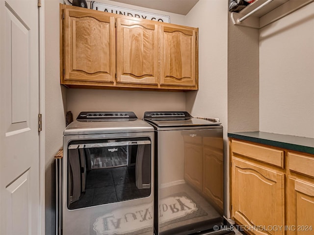 washroom featuring washing machine and dryer and cabinets