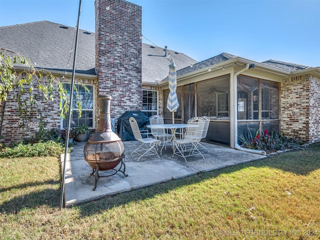 view of patio / terrace featuring a sunroom and an outdoor fire pit