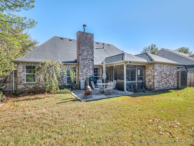 rear view of house featuring a sunroom, a patio area, a fire pit, and a lawn