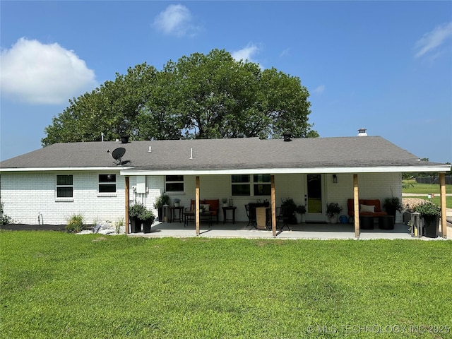 back of property with a lawn and a patio