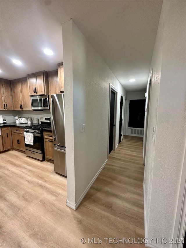 kitchen featuring stainless steel appliances and light hardwood / wood-style flooring