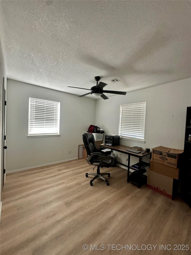 unfurnished office with ceiling fan, light hardwood / wood-style flooring, and a textured ceiling