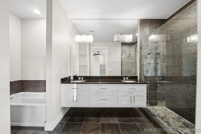 full bath featuring ceiling fan, a sink, a tile shower, a bath, and double vanity