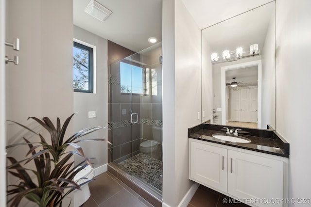 bathroom with an enclosed shower, vanity, tile patterned flooring, and toilet