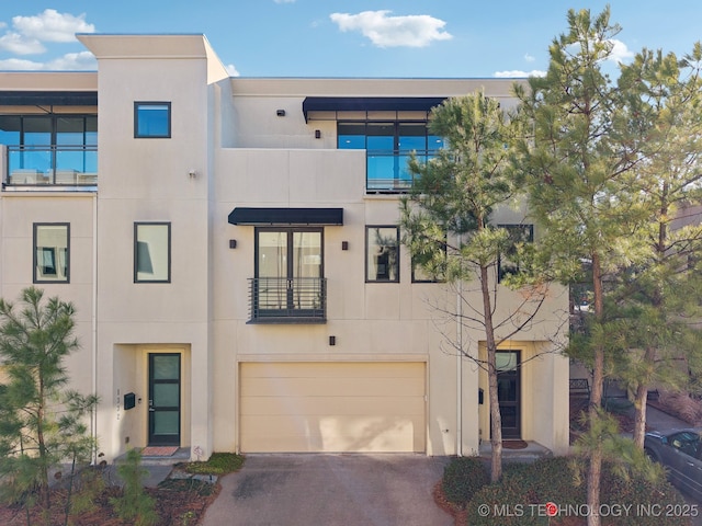 view of front facade with a garage, concrete driveway, and stucco siding