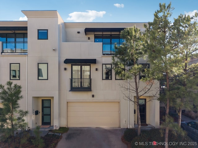 view of front facade featuring concrete driveway, an attached garage, and stucco siding