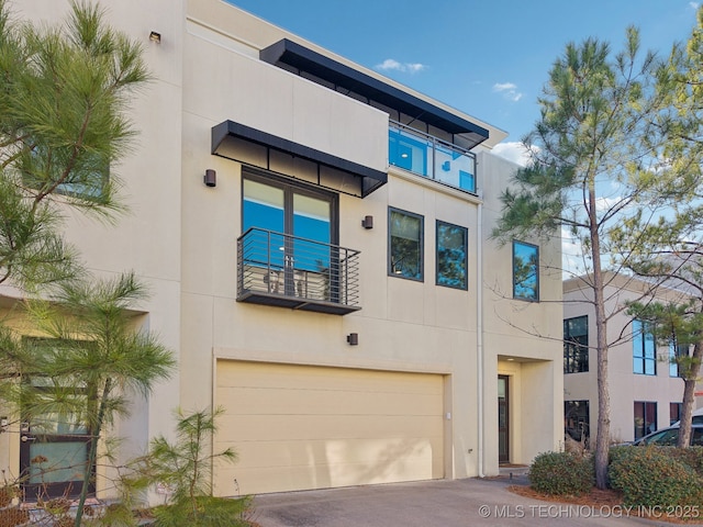 view of building exterior featuring an attached garage and driveway