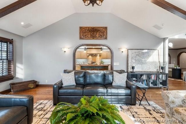 living room featuring an inviting chandelier, high vaulted ceiling, and light hardwood / wood-style floors