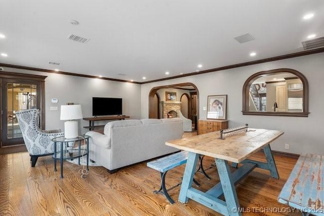 living room with crown molding and light wood-type flooring