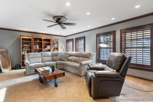 carpeted living room featuring ornamental molding and ceiling fan