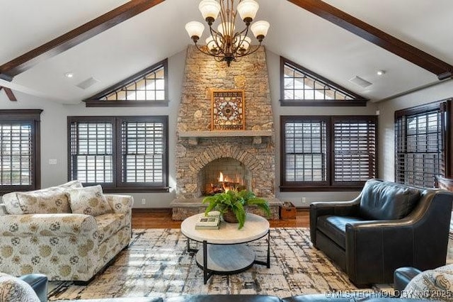 living room featuring hardwood / wood-style flooring, a stone fireplace, a healthy amount of sunlight, and beamed ceiling