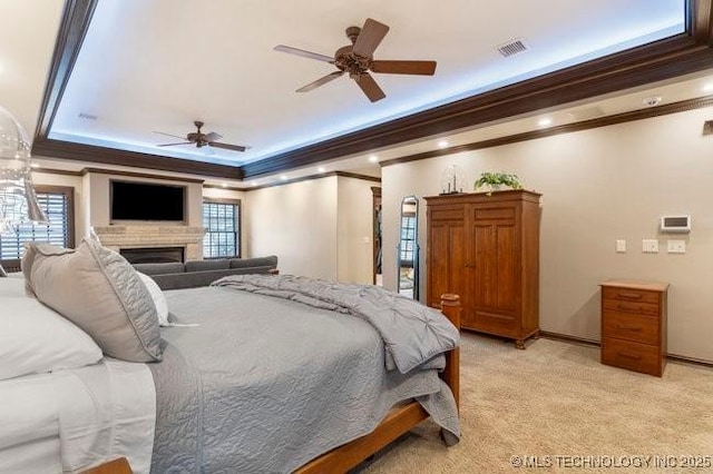 carpeted bedroom featuring multiple windows, ornamental molding, and a raised ceiling