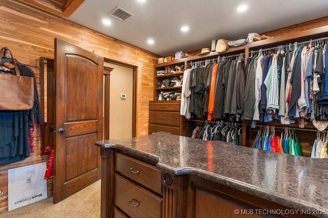 walk in closet with light colored carpet